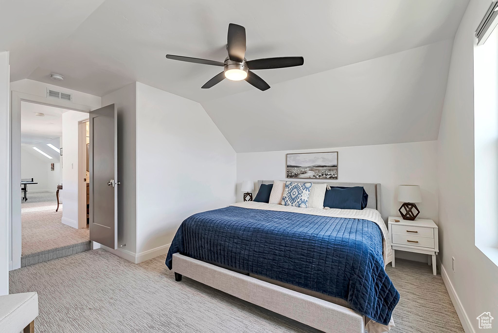 Bedroom with vaulted ceiling, ceiling fan, carpet flooring, and visible vents