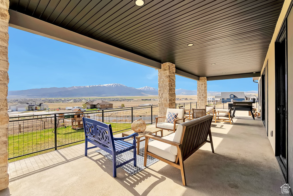 View of patio / terrace featuring a mountain view, an outdoor hangout area, and fence