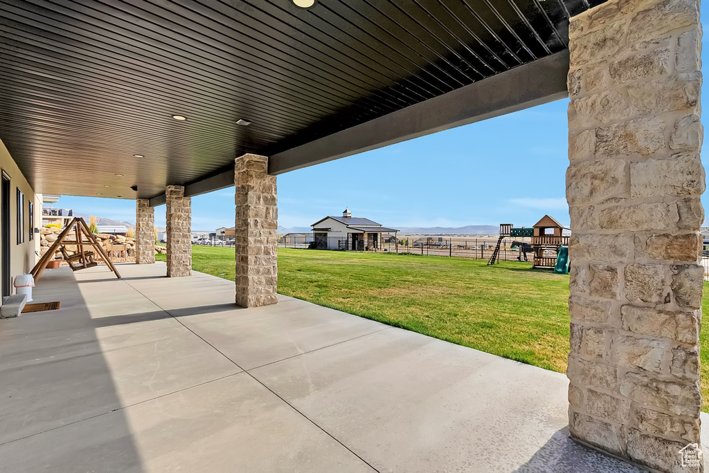 View of patio / terrace featuring a playground and fence