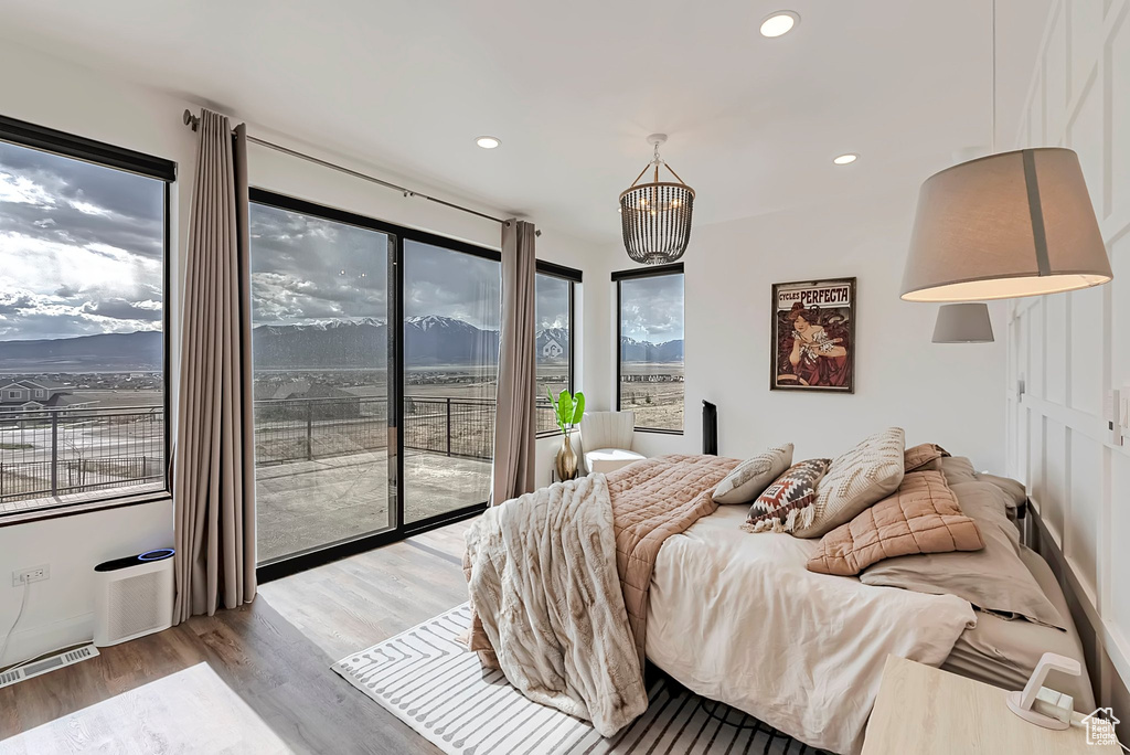 Bedroom featuring access to outside, recessed lighting, wood finished floors, and visible vents