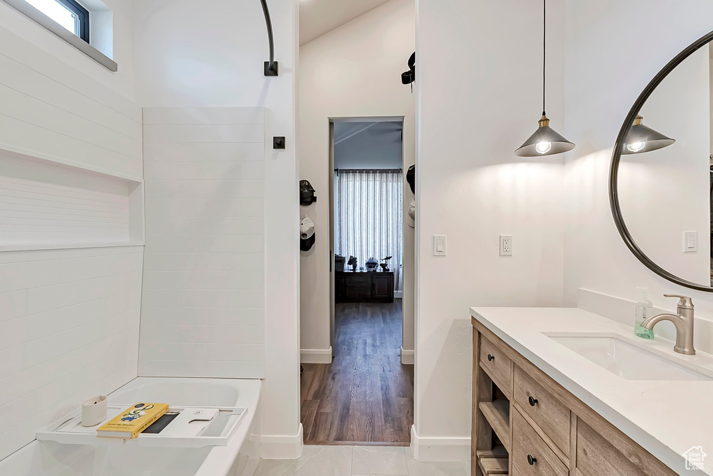 Bathroom with vanity, baseboards, ensuite bathroom, and wood finished floors
