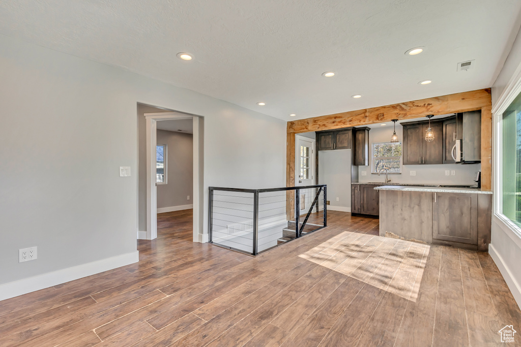 Kitchen featuring recessed lighting, light countertops, baseboards, and wood finished floors