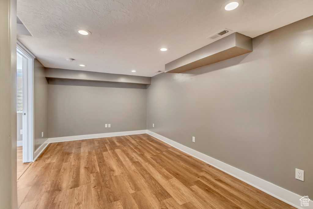 Below grade area with visible vents, recessed lighting, light wood-style floors, and baseboards