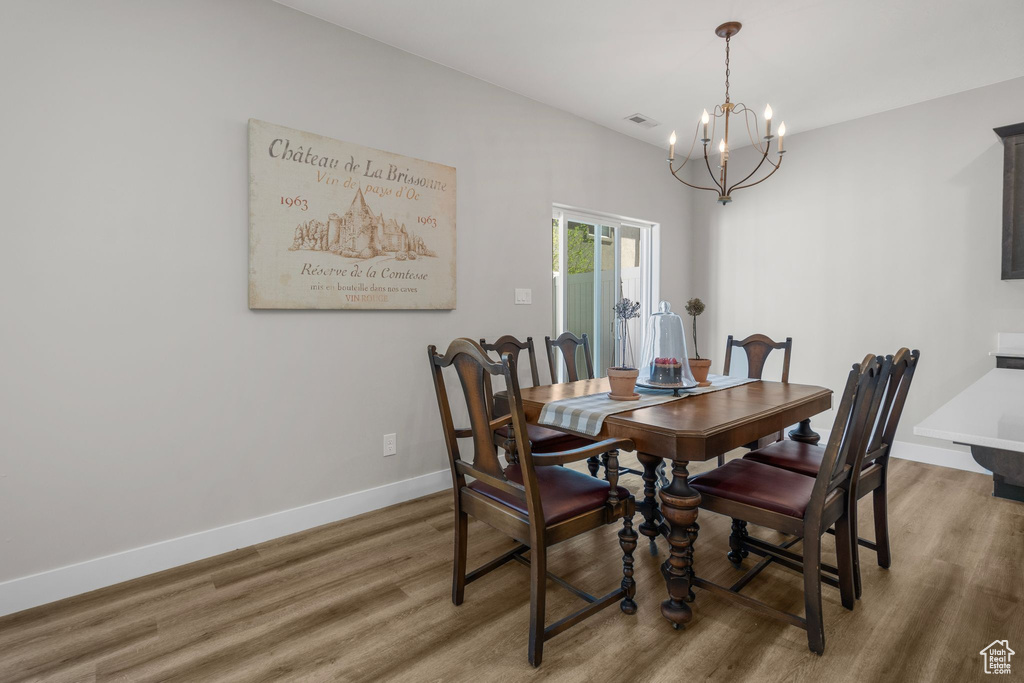 Dining area featuring visible vents, baseboards, an inviting chandelier, and light wood finished floors