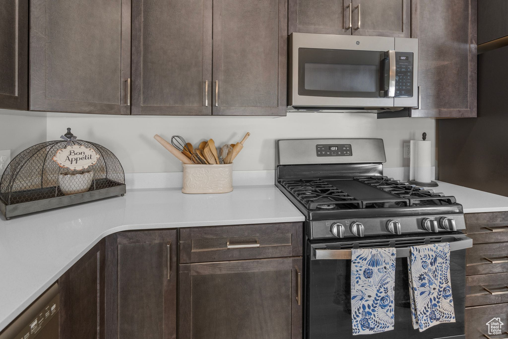 Kitchen with light countertops, appliances with stainless steel finishes, and dark brown cabinetry