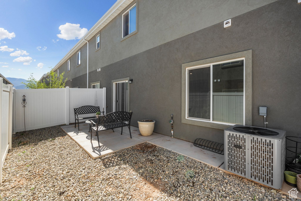 Back of house with a patio, central AC, a fenced backyard, and stucco siding