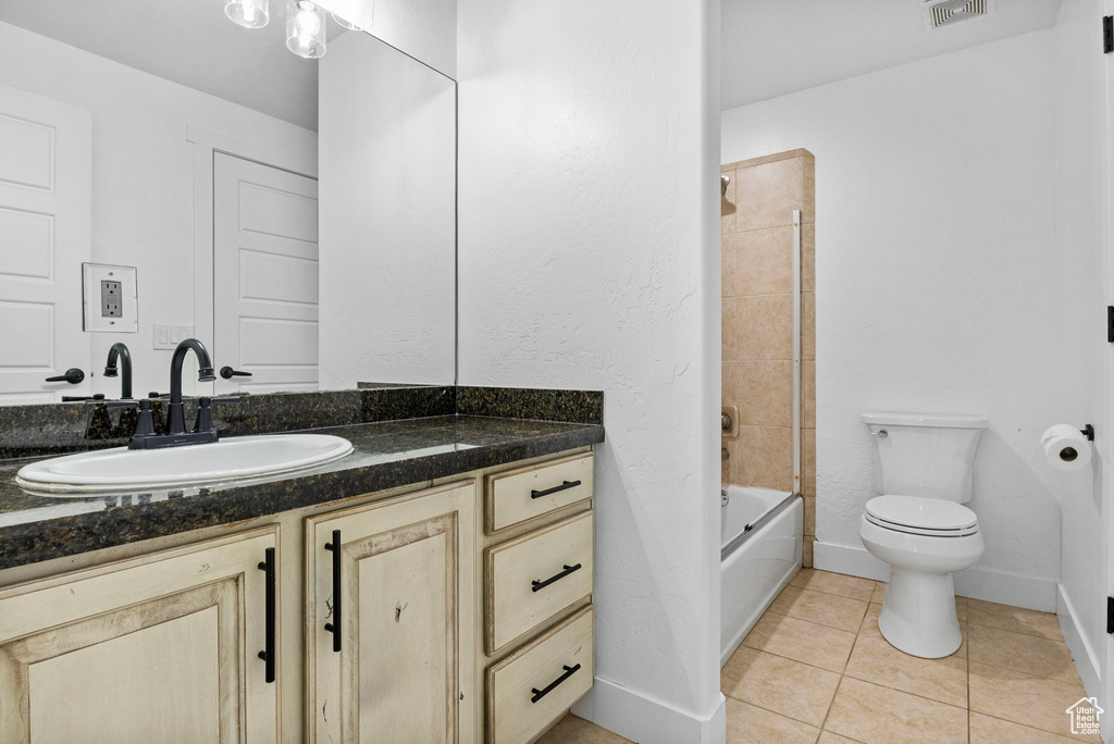 Bathroom with shower / bath combination, visible vents, vanity, tile patterned floors, and toilet