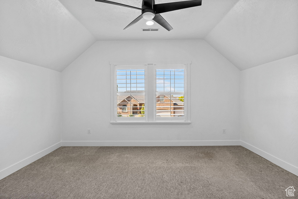 Additional living space featuring carpet floors, ceiling fan, vaulted ceiling, and visible vents