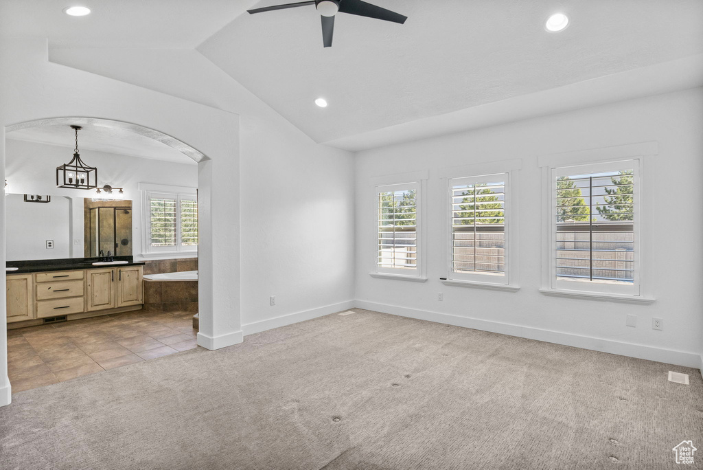 Unfurnished bedroom featuring multiple windows, vaulted ceiling, recessed lighting, and light colored carpet