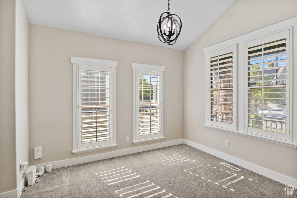 Unfurnished dining area with visible vents, vaulted ceiling, baseboards, a notable chandelier, and carpet flooring