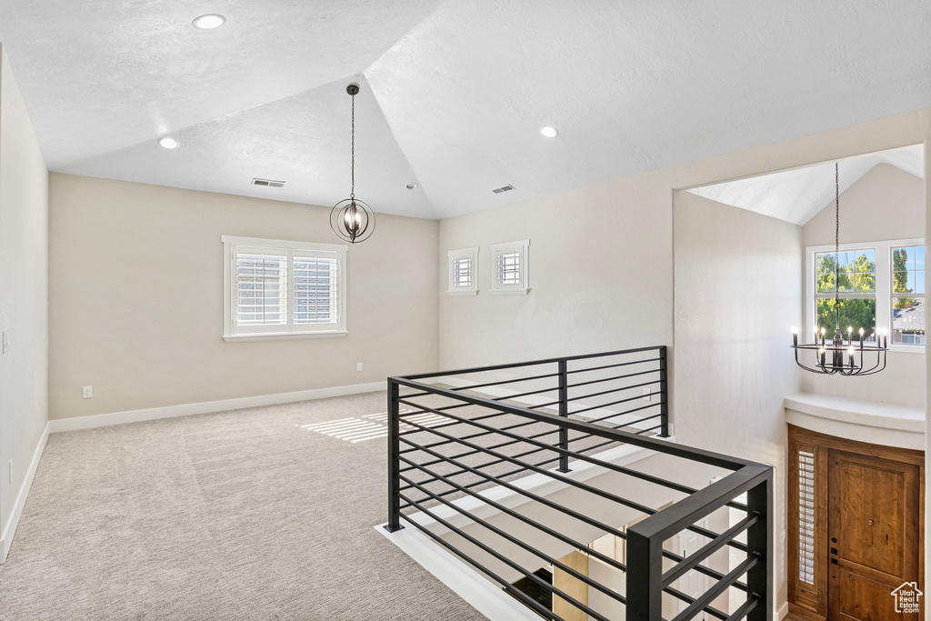 Interior space featuring plenty of natural light, lofted ceiling, and a notable chandelier