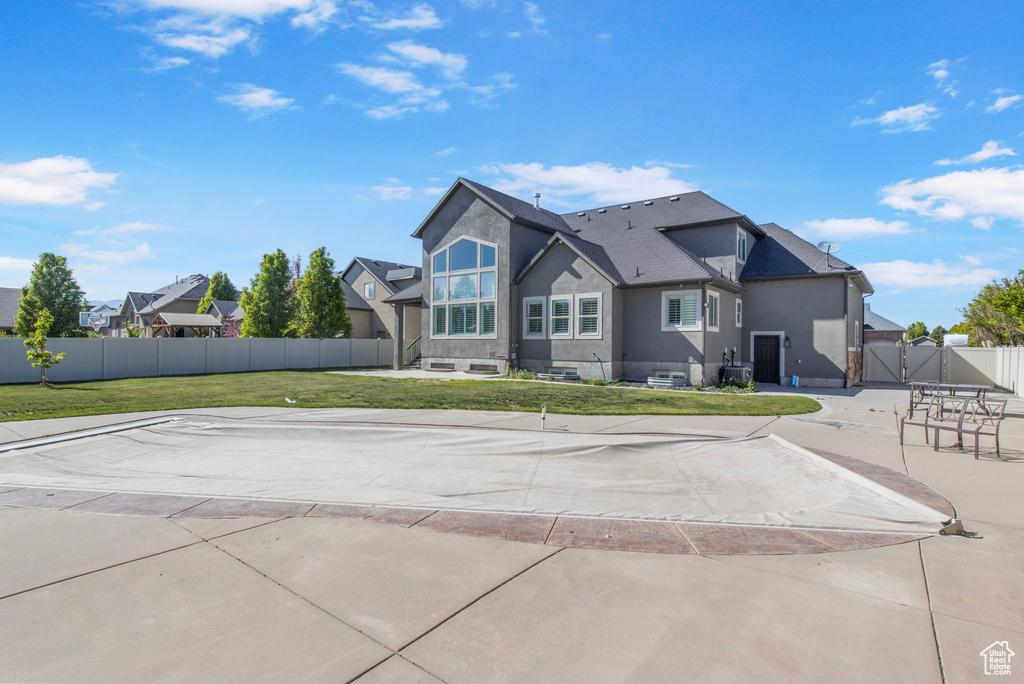 Exterior space with a yard, fence, a gate, and stucco siding