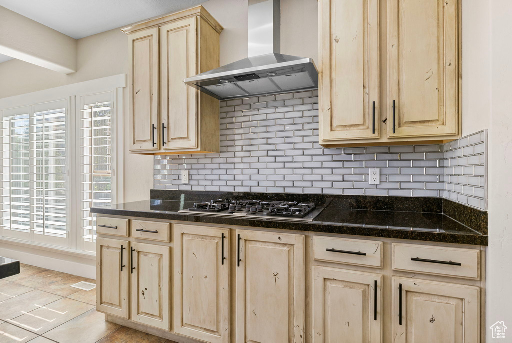 Kitchen featuring stainless steel gas stovetop, light brown cabinetry, and extractor fan