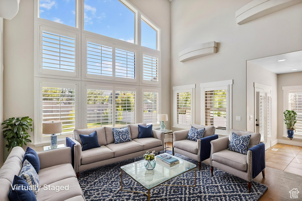 Living room featuring tile patterned flooring, baseboards, and a high ceiling