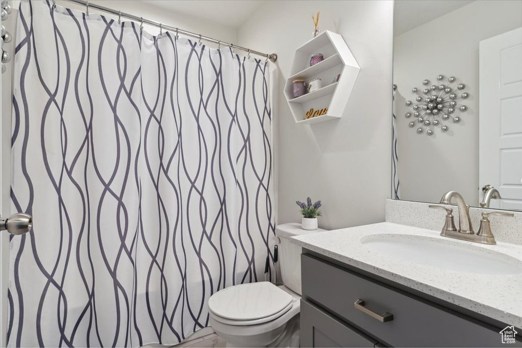 Full bath with vanity, a shower with curtain, and toilet