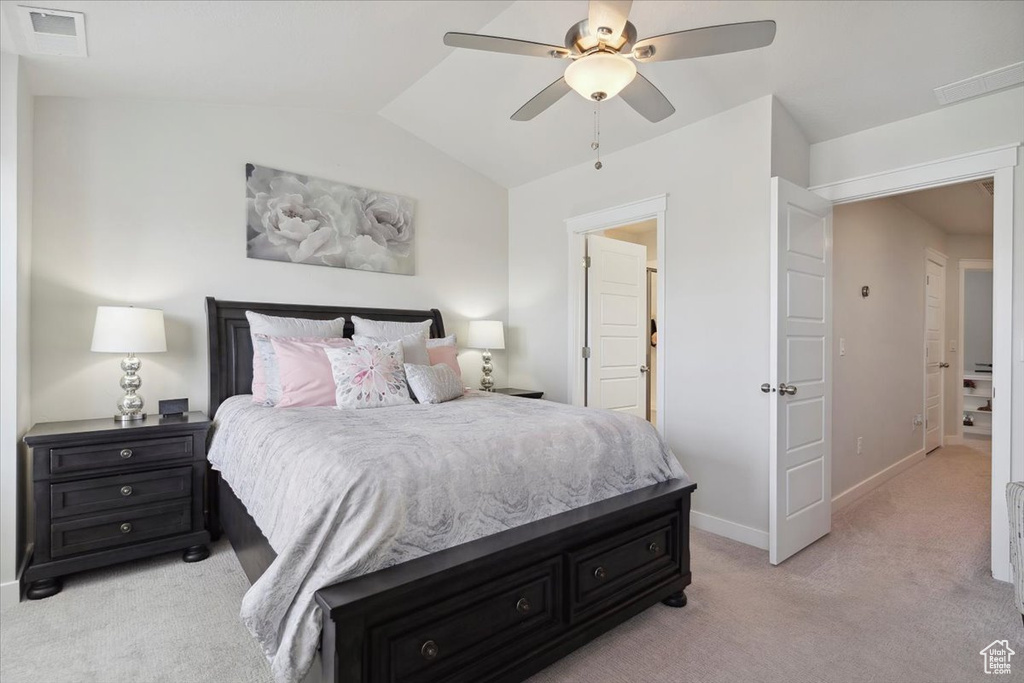 Bedroom featuring visible vents, light carpet, baseboards, a ceiling fan, and vaulted ceiling