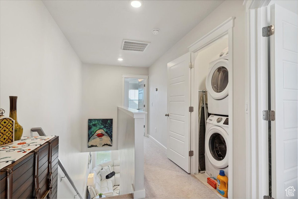 Washroom with laundry area, visible vents, light carpet, stacked washer and clothes dryer, and recessed lighting