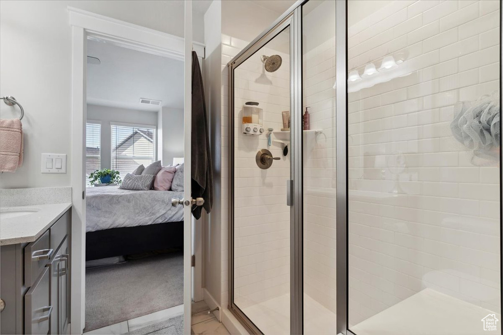 Ensuite bathroom with vanity, ensuite bathroom, a stall shower, and visible vents