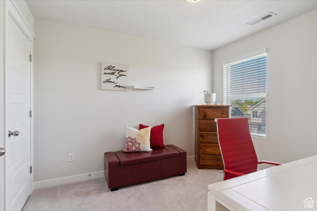 Home office featuring visible vents, baseboards, and light carpet