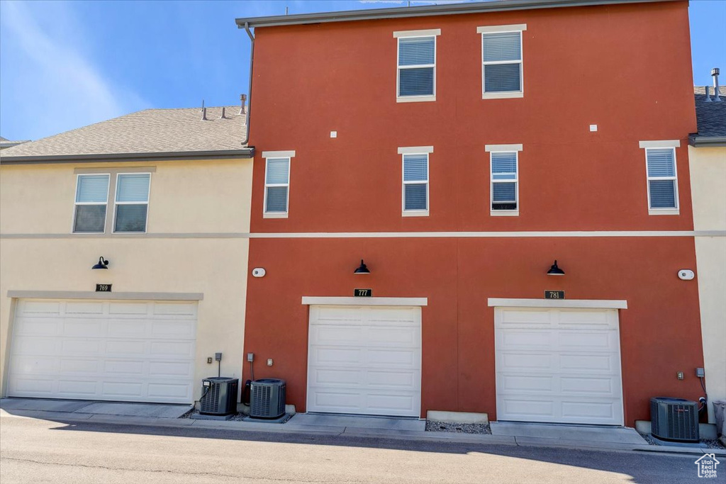 Rear view of property with cooling unit and stucco siding