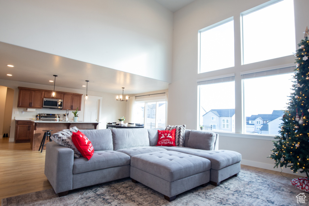 Living area featuring an inviting chandelier, recessed lighting, plenty of natural light, and light wood finished floors