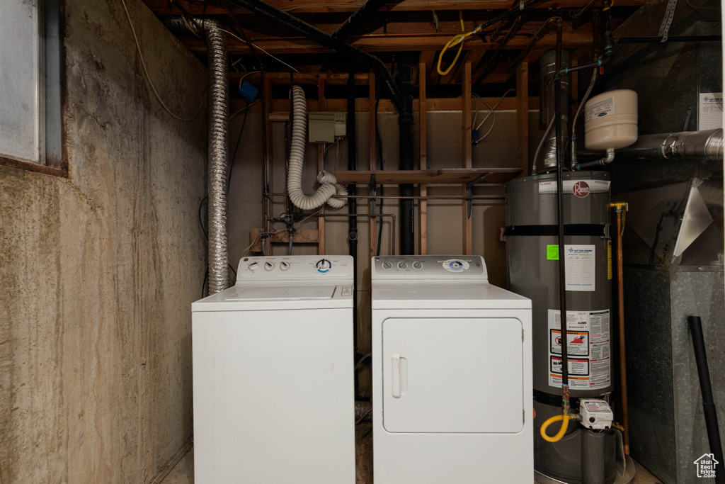Laundry room with laundry area, water heater, and washer and dryer