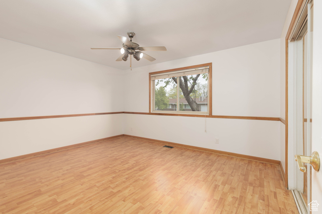 Empty room featuring baseboards, ceiling fan, and light wood finished floors