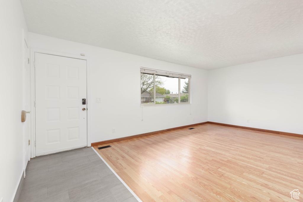 Interior space featuring baseboards, a textured ceiling, and visible vents