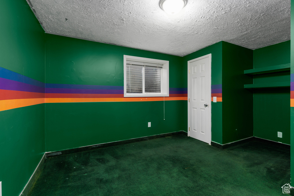 Unfurnished room with baseboards, carpet flooring, and a textured ceiling