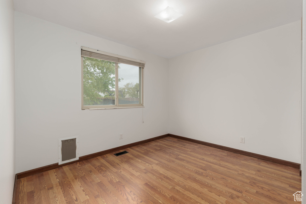 Empty room featuring baseboards, visible vents, and light wood-style floors