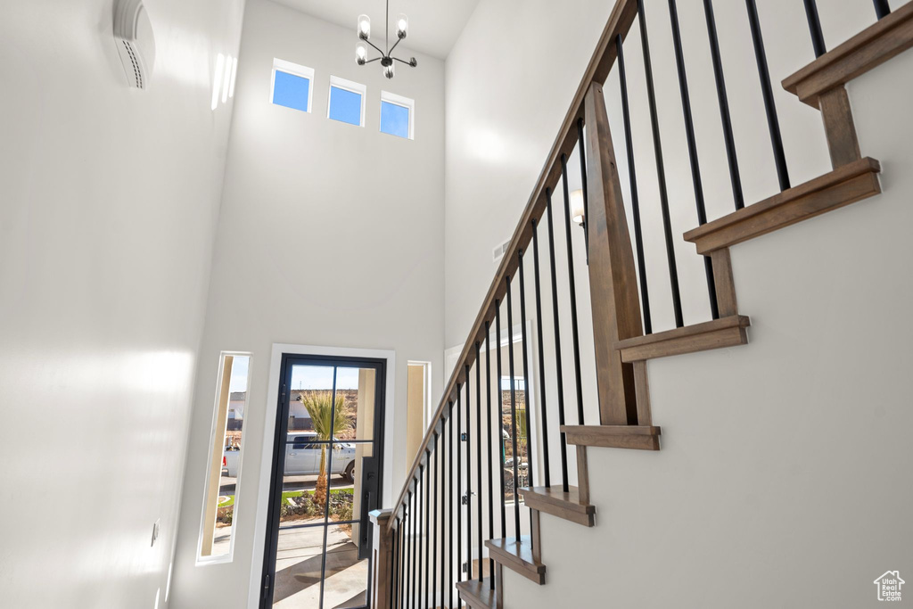 Entryway with a healthy amount of sunlight, a high ceiling, and a notable chandelier