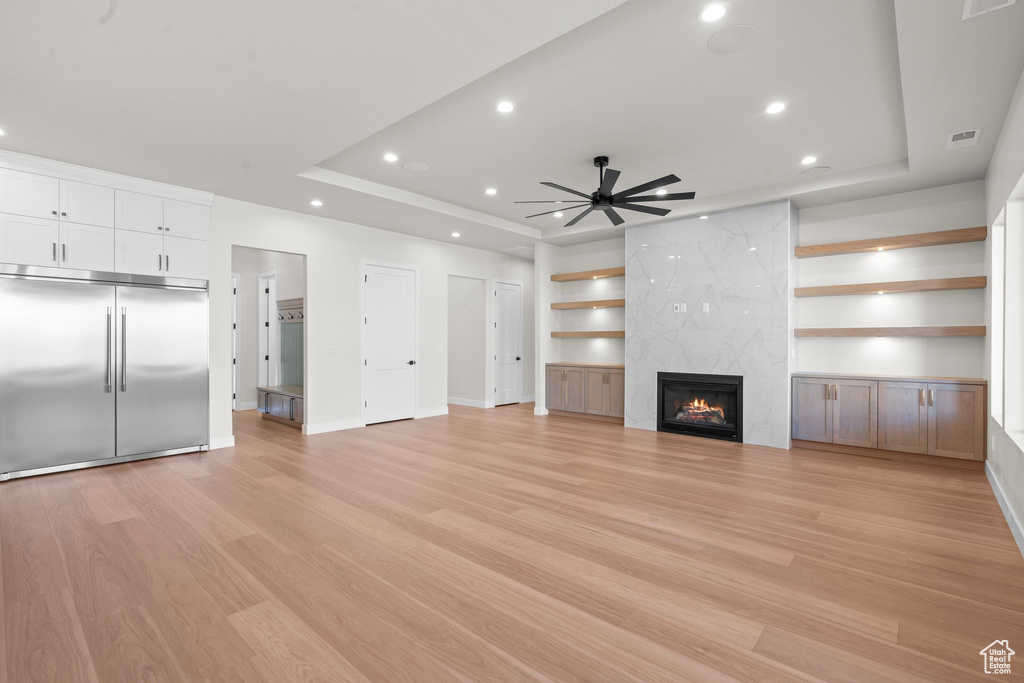 Unfurnished living room featuring visible vents, recessed lighting, a raised ceiling, and a premium fireplace