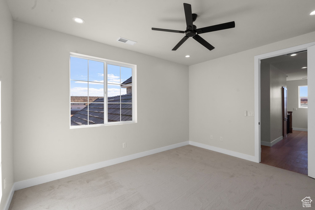 Carpeted spare room featuring visible vents, recessed lighting, baseboards, and a ceiling fan