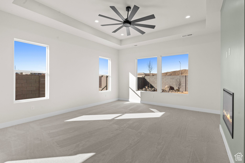 Unfurnished room featuring visible vents, a tray ceiling, recessed lighting, and light colored carpet