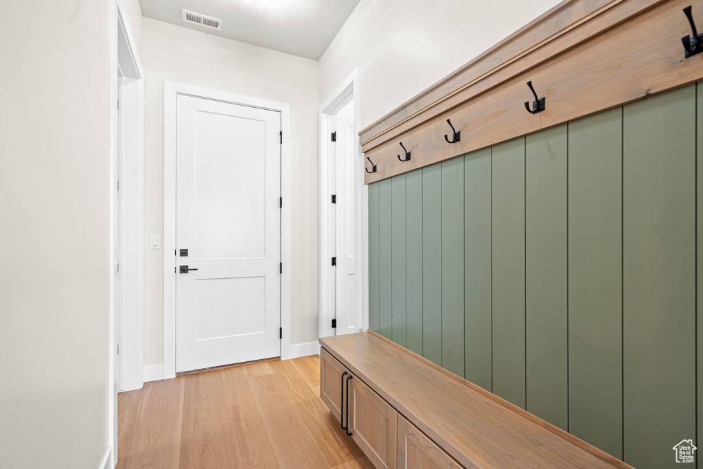 Mudroom with visible vents, baseboards, and light wood-type flooring
