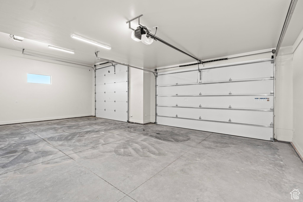 Garage with baseboards and a garage door opener
