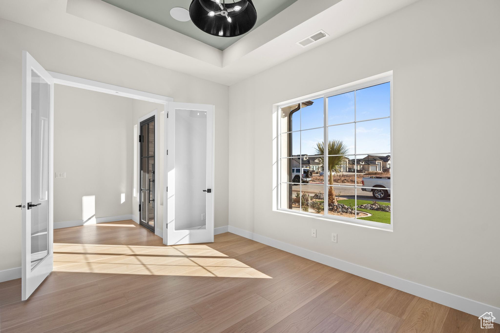 Unfurnished room featuring baseboards, visible vents, french doors, and wood finished floors