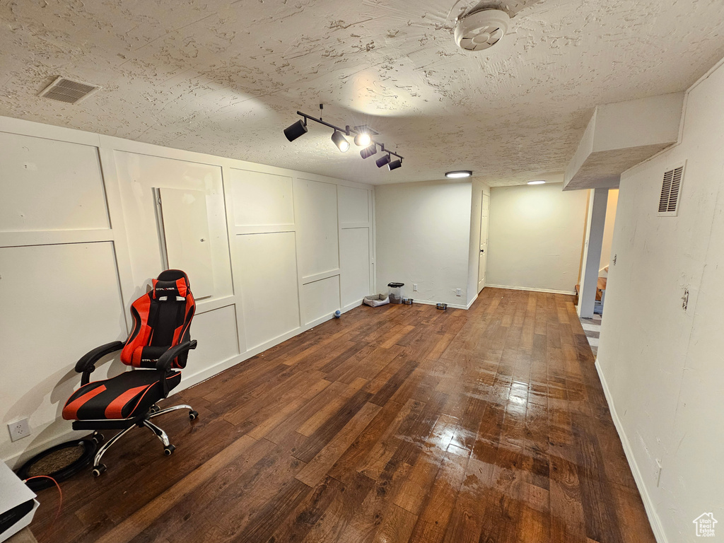 Unfurnished office with baseboards, wood-type flooring, a textured ceiling, and visible vents