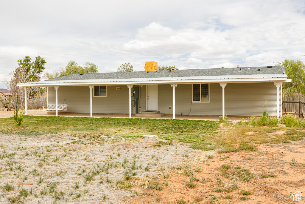 View of front of property featuring fence and a patio area