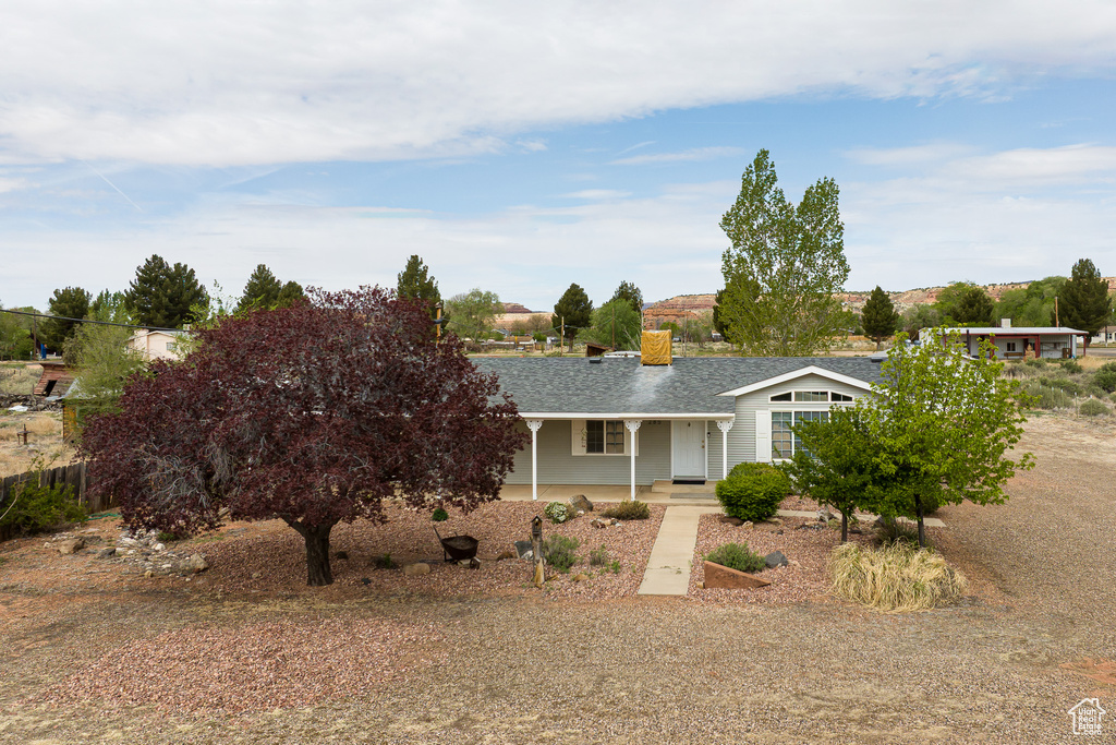 View of front of home featuring a shingled roof and a porch