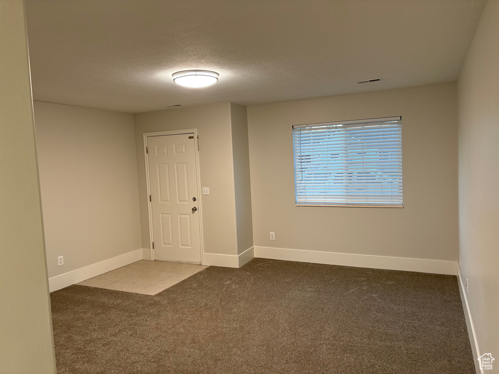 Carpeted entryway with baseboards and a textured ceiling