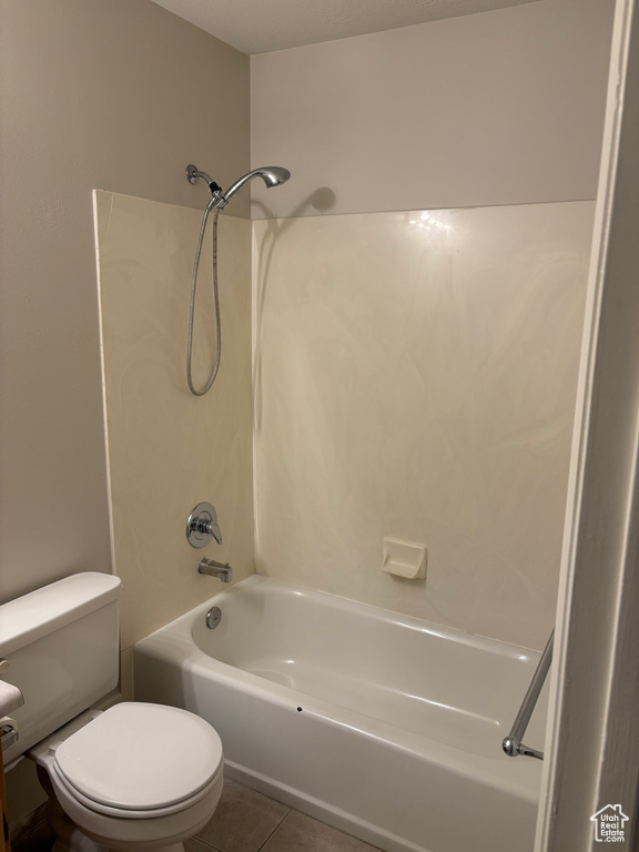 Bathroom featuring toilet, washtub / shower combination, and tile patterned flooring