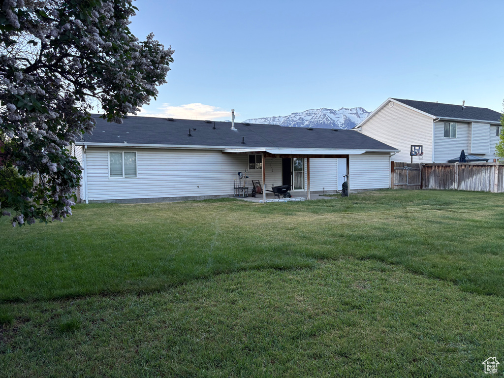 Back of property featuring a patio, fence, and a yard