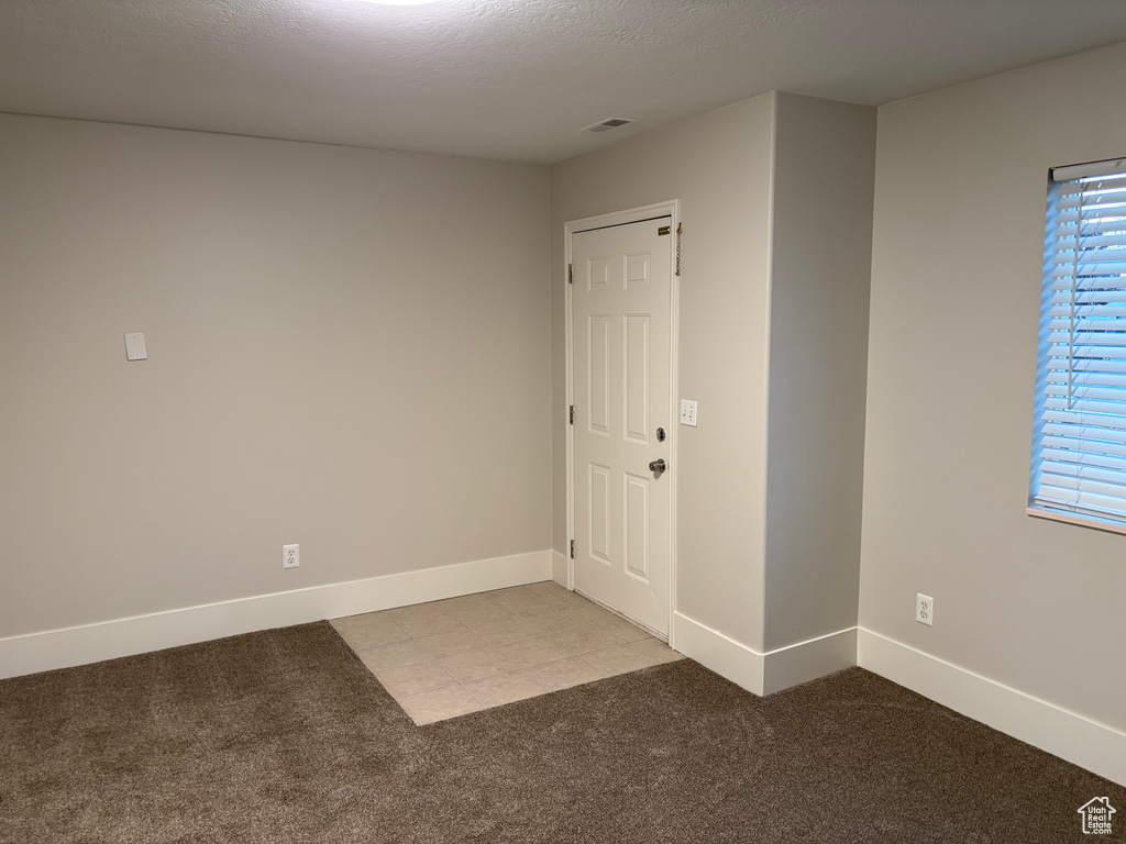 Unfurnished room featuring baseboards, visible vents, and carpet