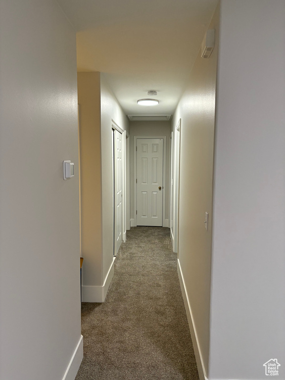 Corridor featuring carpet flooring and baseboards