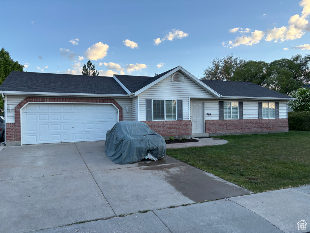 Ranch-style home with a front lawn, brick siding, a shingled roof, concrete driveway, and an attached garage