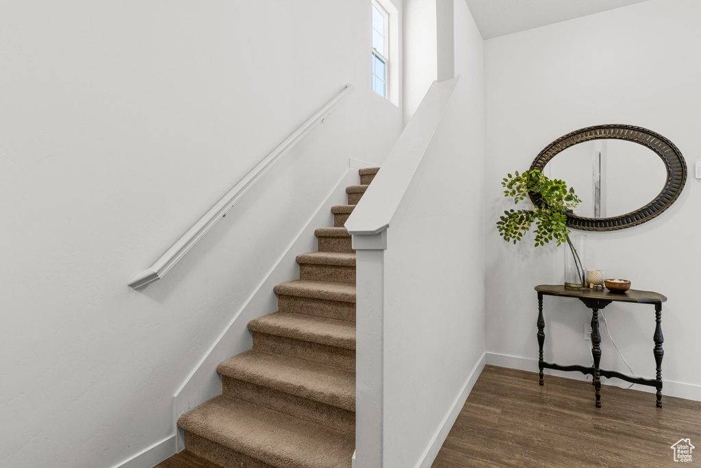 Staircase featuring baseboards and wood finished floors