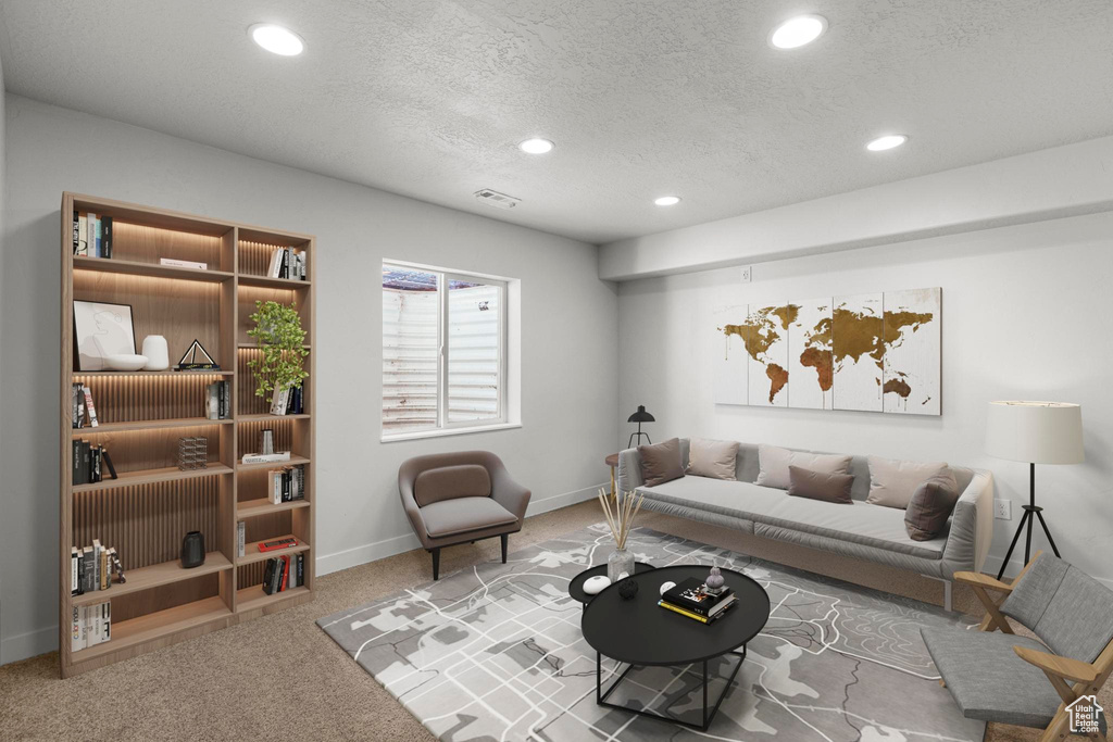 Carpeted living area with recessed lighting, baseboards, visible vents, and a textured ceiling