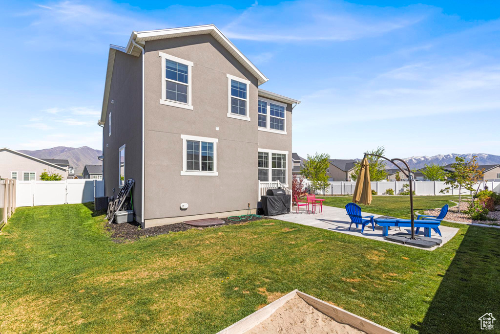 Back of house featuring a yard, a patio, a fenced backyard, and stucco siding