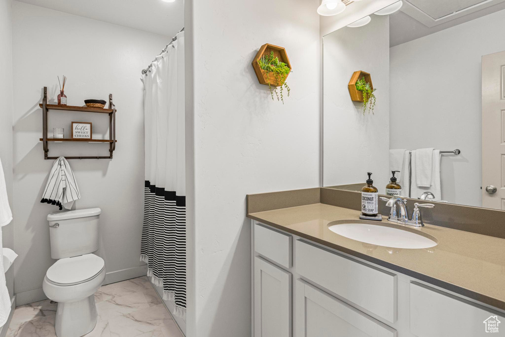 Full bathroom with toilet, baseboards, marble finish floor, and vanity